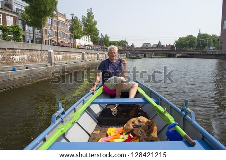 Man with boat and dog in Amersfoort at the Eem river