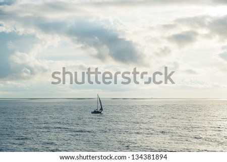 Lonely sail boat at the open sea