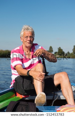 Elderly man in boat at the river