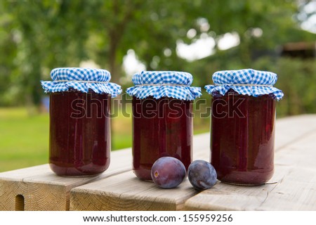 Homemade glass pots jam with fresh fruit in the orchard