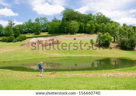Man walking the dog near Little lake in the French Dordogne