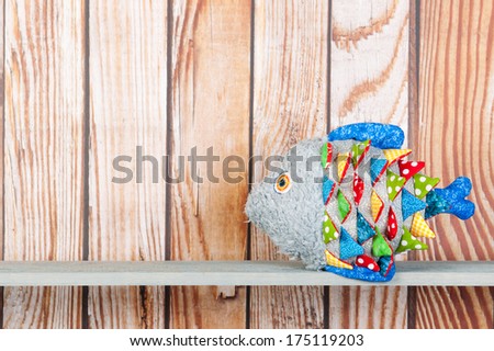 Stuffed colorful funny fantasy fish at home on wooden background