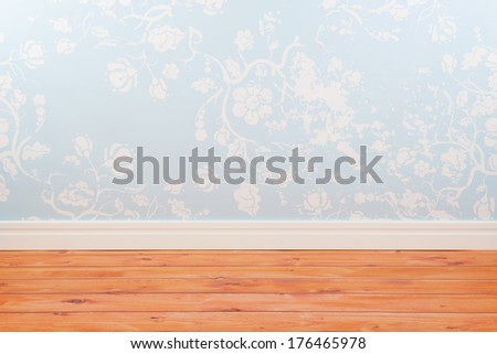 Room with blue vintage wall paper and wooden floor