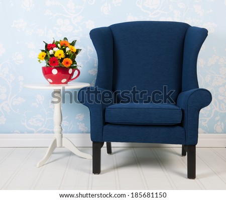 Interior blue living with vintage wall paper chair, table and flowers