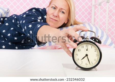 woman of mature age put out the alarm clock in the morning