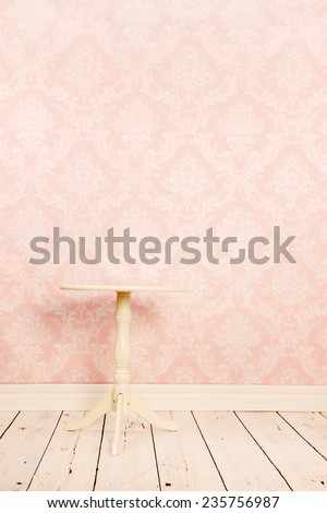Vintage table in interior with old wall paper