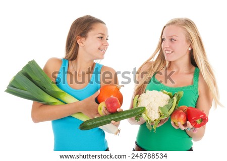 Teen girlfriends with many healthy vegetables and fresh fruit isolated over white background