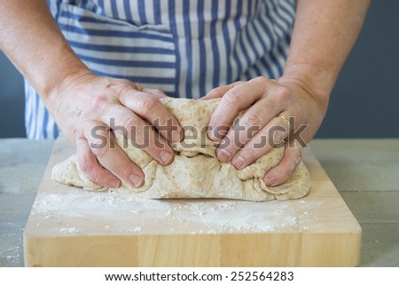 Female hands kneading bread dough