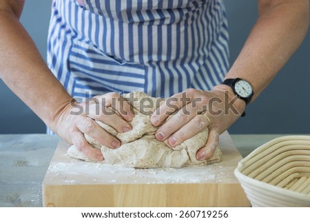 Female hands kneading bread dough