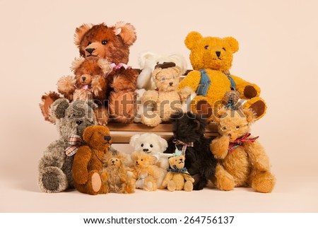 Stuffed vintage bears sitting on bench for family portrait at beige background