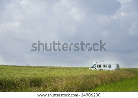 camping car standing in landscape with fields