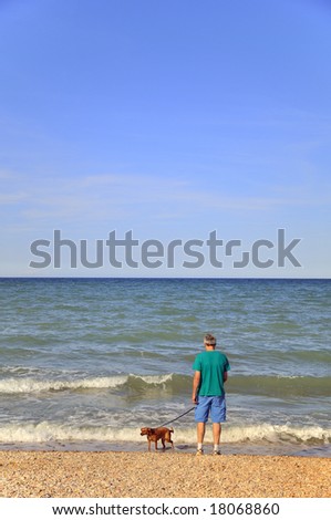 Elderly man is walking the dog at the beach