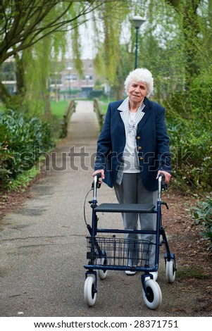 Very old lady with blue walker walking outdoor