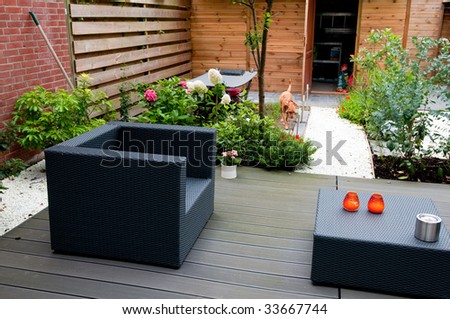 Modern Garden Furniture on Modern Garden With Grey Furniture Flowers And A Dog Stock Photo