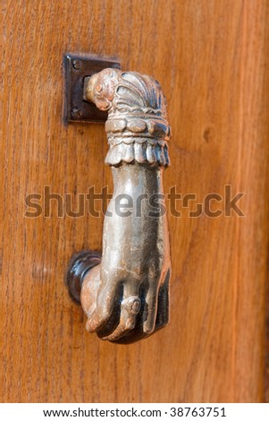 Knocking on the wooden door with copper hand