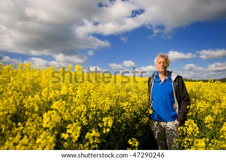 Landscape with man in yellow cole seed and clouds