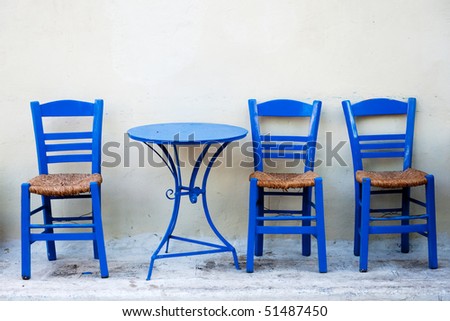 Traditional Greek terrace with blue tables and chairs