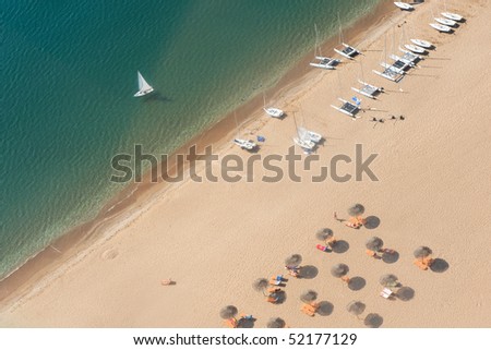 Beach vacation with sun tanning and sail boats