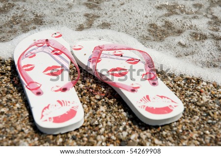 flip flops in the water line at the beach