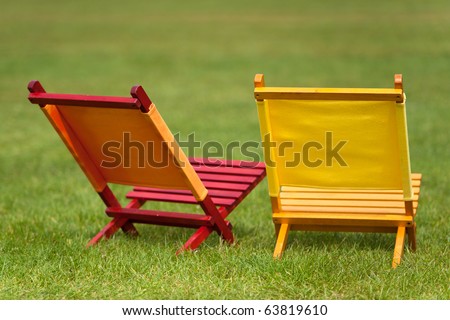 Empty colorful chairs in red and yellow in the grass