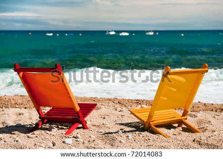 empty orange and yellow chairs at the tranquil beach