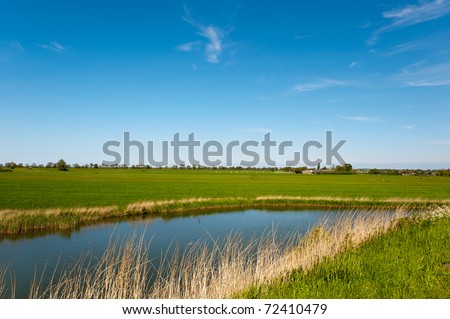 Typical Dutch flat landscape with pastures and water