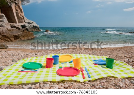 picnic with colorful plastic crockery at the beach