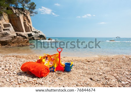 Beach bag, rolled towel and plastic toys for vacation