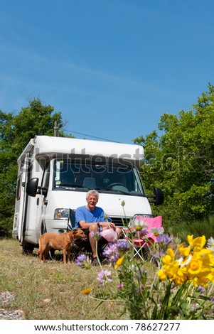 Man with his dog is travel by camping car
