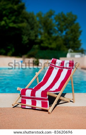 Beach chair with towel near the swimming pool