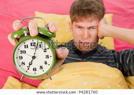 man is waking up with alarm clock with bells