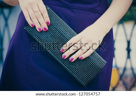 Women holding a black leather bag in her hand
