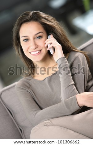 young attractive woman talking on the telephone at home