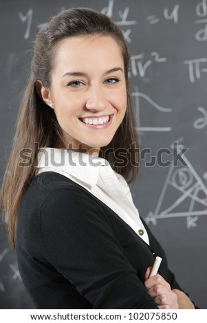 portrait of a happy student in front of a blackboard