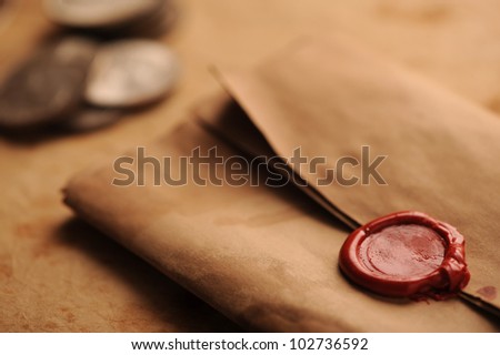 wax seal on a grunge paper, old coins on background