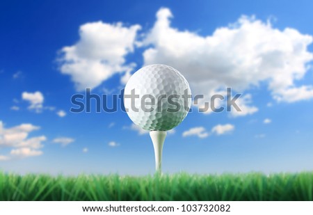 Golf ball in the grass against a  blue sky