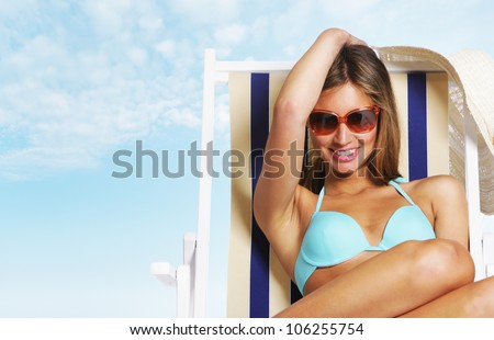 Beautiful young woman relaxing on beach chair