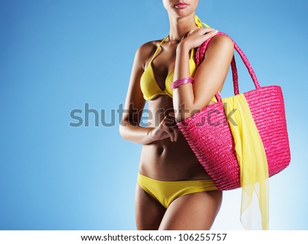 Sexy girl with pink bag and yellow bikini