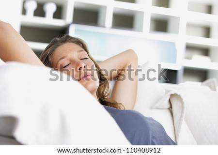 Young beautiful woman sleeping on white couch