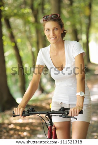 Young woman on a bicycle in the forest