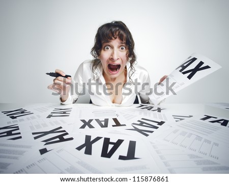Young frightened woman shouting out while sitting at her paperwork-covered desk  with a marker in one hand and a tax bill in the other one