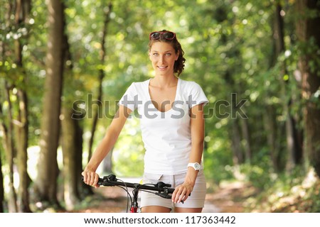 Young woman on a bicycle in the forest