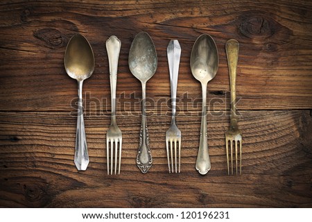 Old forks and spoons on wooden background