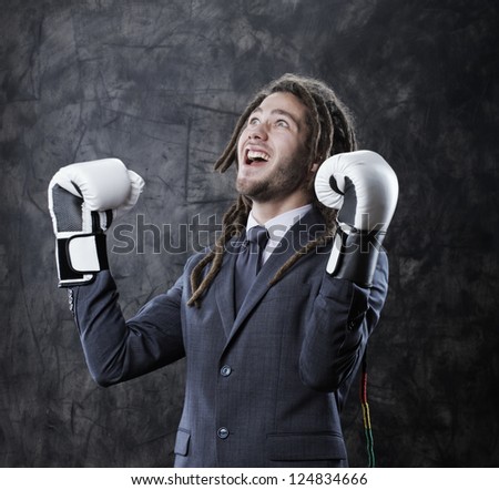 Young businessman shouting his victory, he wearing boxes gloves