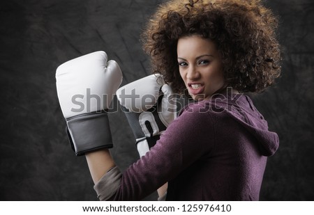 Aggressive beautiful girl with white boxing gloves ready to fight
