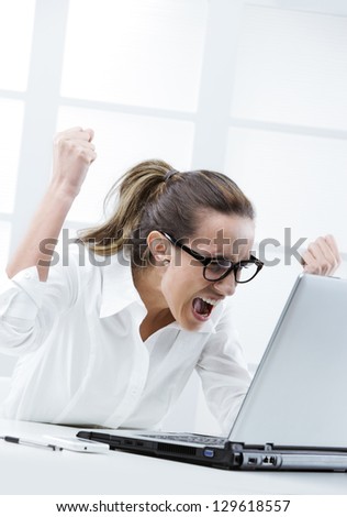 Freaked out businesswoman ready to smash her laptop computer