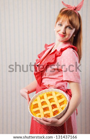 Retro housewife holding hot italian pie.