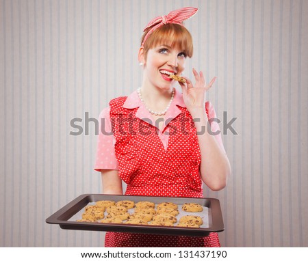 Retro housewife holding cookie tray full of chocolate cookie