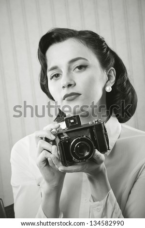 Beautiful business woman with a old camera