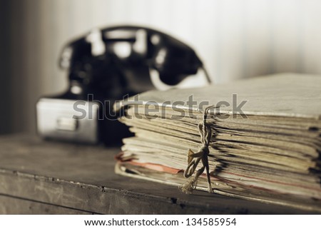 A desk with documents, Old phone on the background